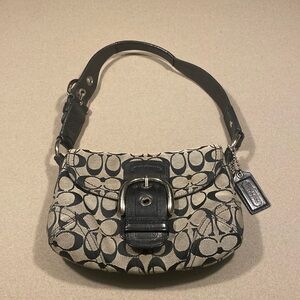 Vintage signature, Jacquard, black and gray coach used purse. Over the shoulder.